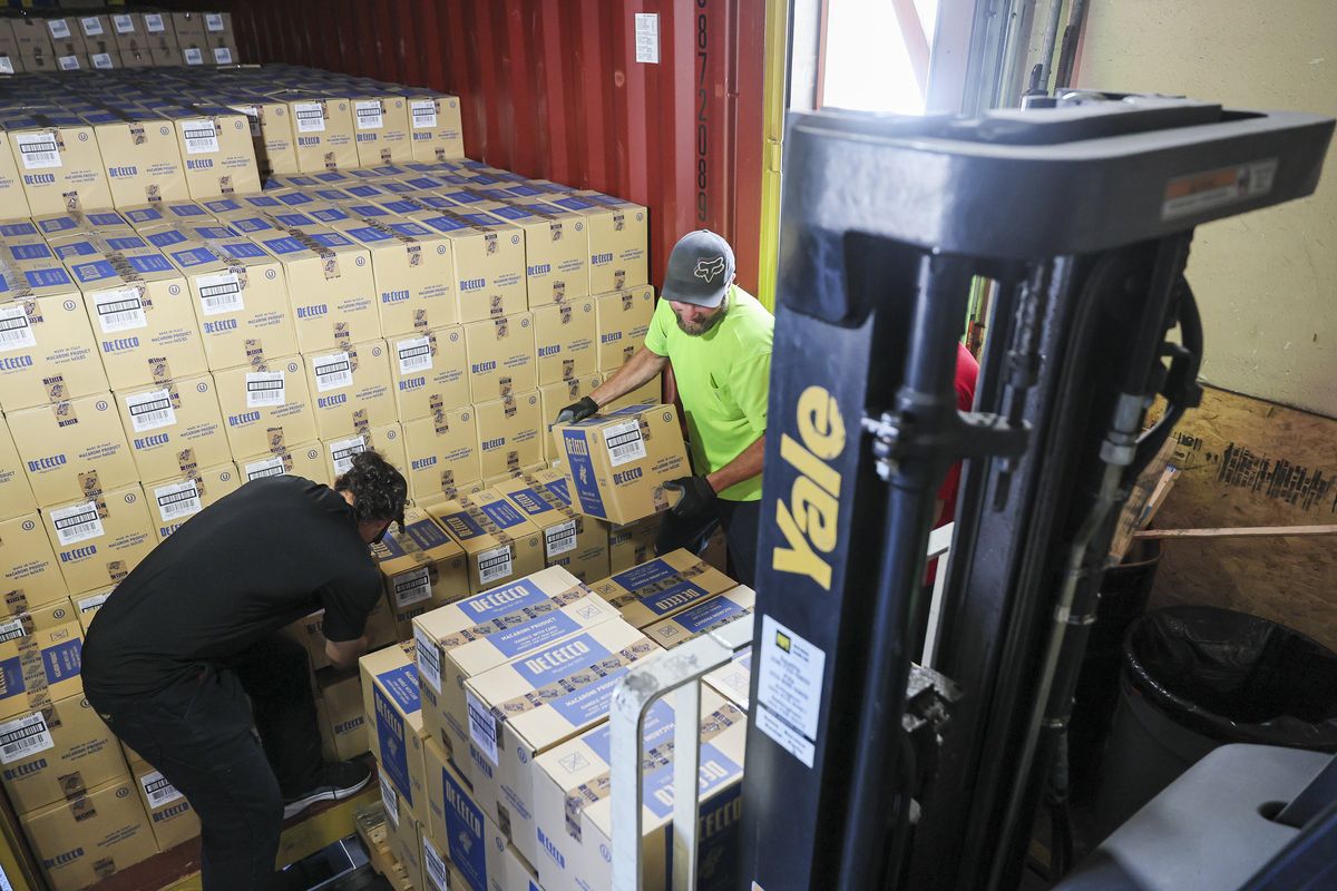 Warehouse associates unload a freshly arrived shipment of pasta from Italy on Aug. 22 at Merlino Foods in Seattle. (Kevin Clark/The Seattle Times/TNS)