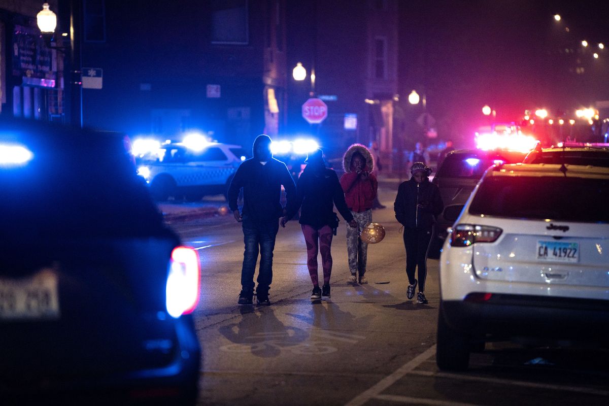 Neighbors wait to move their vehicle at the scene where at least a dozen people were shot, including children, on Halloween night near Polk Street and California Avenue.  (E. Jason Wambsgans/Chicago Tribune/TNS)
