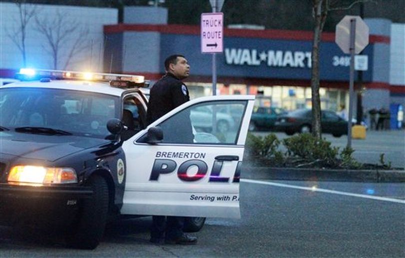 A Bremerton police officer guards the perimeter of the Walmart parking lot in Port Orchard, Wash. where a Washington state sheriff said a shooting left one person dead and two sheriff's deputies wounded Sunday afternoon, Jan. 23, 2011.  (Drew Perine / (AP Photo/The News Tribune, Drew Perine))