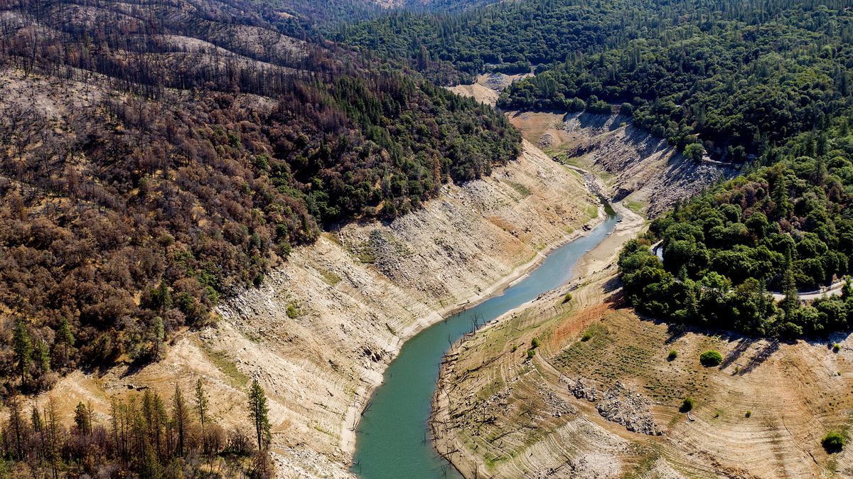 Dry banks rise above water in Lake Oroville on Sunday, May 23, 2021, in Oroville, Calif. At left are trees scorched in the 2020 North Complex Fire. At the time of this photo, the reservoir was at 39 percent of capacity and 46 percent of its historical average. California officials say the drought gripping the U.S. West is so severe it could cause one of the state
