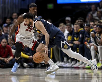 Denver guard Jamal Murray, with ball, drives on Miami’s Jimmy Butler during the second quarter of Game 2 of the NBA Finals at Ball Arena in Denver on Sunday.  (AAron Ontiveroz)