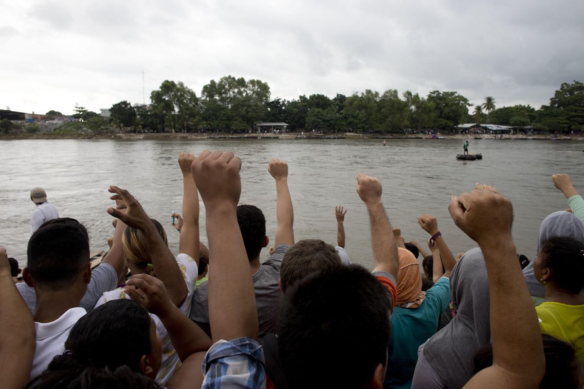 Honduran migrants sing their national anthem standing standing at the shore of the Suchiate river on the border between Guatemala and Mexico, in Tecun Uman, Guatemala, on Thursday, Oct. 18, 2018. Mexico’s foreign ministry says government officials at its southern border with Guatemala have started assisting the early arrivals from a caravan of some 3,000 Honduran migrants that has drawn sharp criticism from U.S. President Donald Trump. (AP)