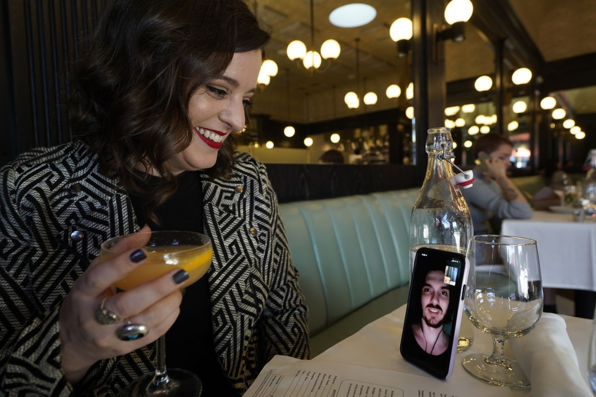 Erin Tridle holds a video chat with her boyfriend Jordan Commarrieu living in Paris from their favorite French restaurant “Petit Trois” on Friday in Los Angeles.  (Damian Dovarganes)