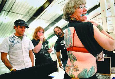 
Cindy Gonzalez shows off her tattoo to Gary Barnett, left, and Patty and Luis Montoya at the Spokane Tattoo Expo held this weekend at the fairgrounds. Gonzalez's tattoo took 30 hours to complete and was created by her daughter, Prairie Dawn. The two are from Eatonville, Wash. 
 (Ingrid Lindemann / The Spokesman-Review)