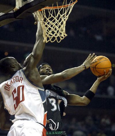 Minnesota's Ricky Davis, right, drives to the basket against Charlotte's Emeka Okafor in first-half action Monday.
(Associated Press / The Spokesman-Review)