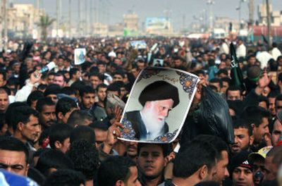 
An Iraqi man holds a picture of prominent Shiite cleric Ayatollah Mohammed Sadeq al-Sadr during a political demonstration supporting the United Iraqi Alliance after Friday prayers at Al-Sadr city east of Baghdad on Friday. 
 (Associated Press / The Spokesman-Review)