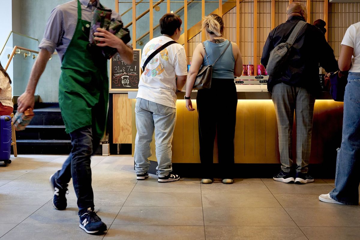 Customers wait to pick up their orders at a Starbucks location in New York.  (Gabby Jones/Bloomberg)