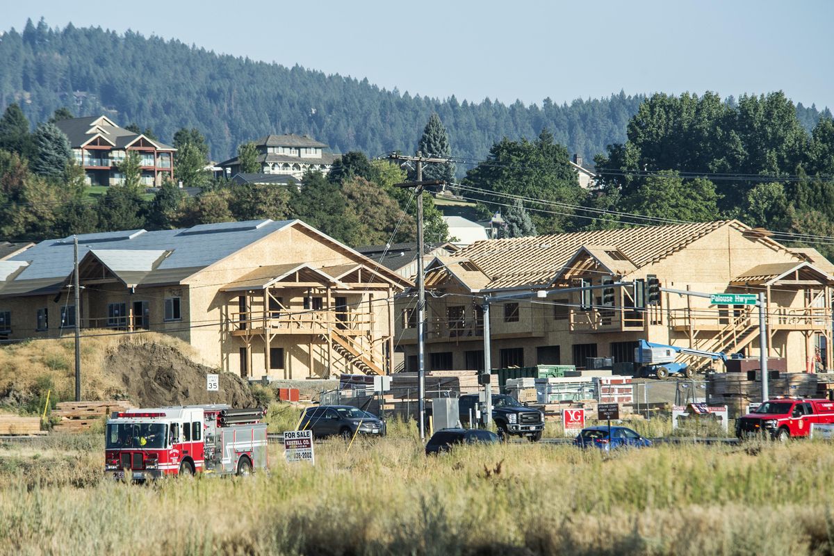 A Spokane Fire District 8 engine responds to a call past new apartment construction Sept. 11, 2017, near the corner of 57th Avenue and Palouse Highway in  Moran Prairie. (Dan Pelle / The Spokesman-Review)