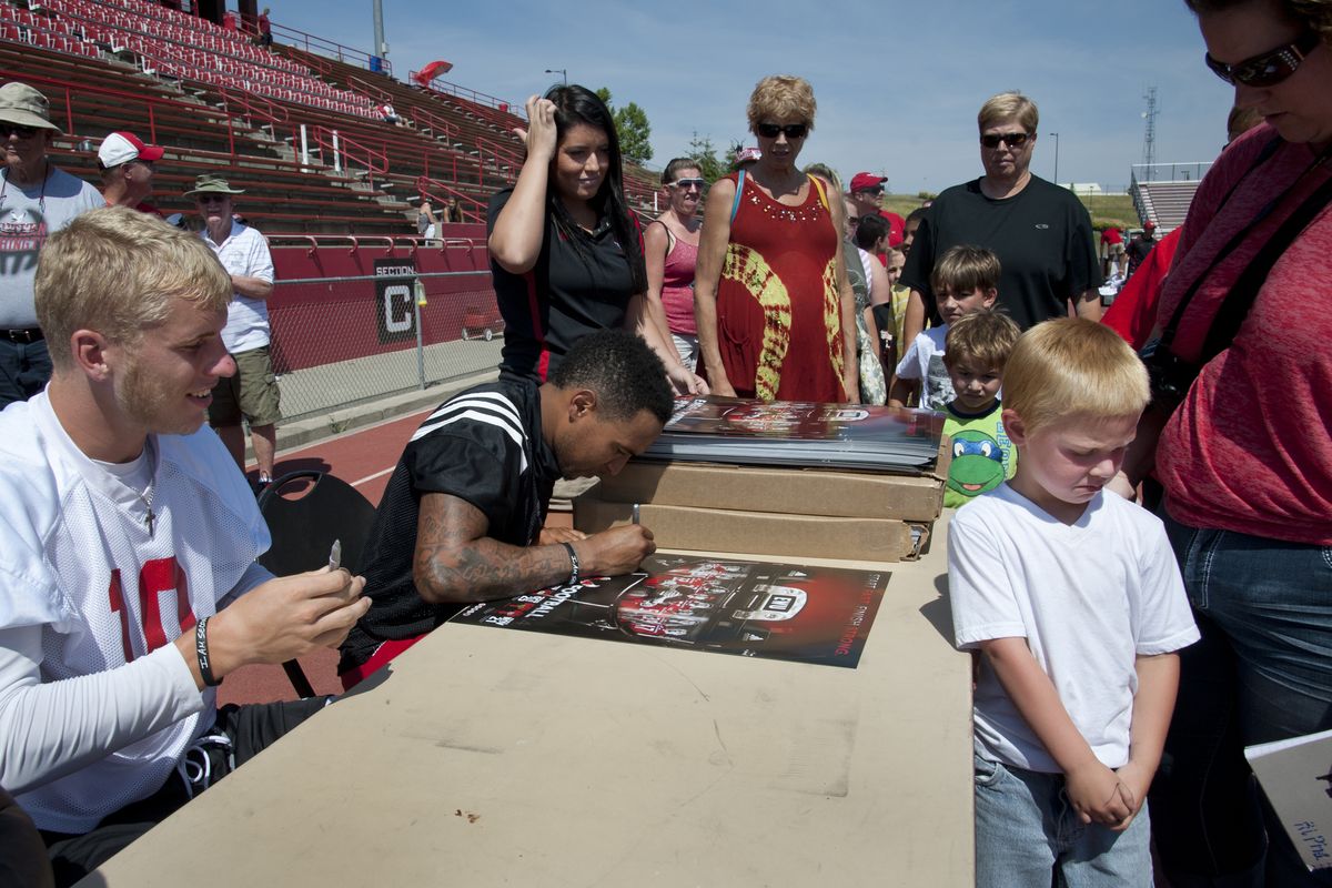 Left, Eagles’ Kendrick Bourne hauls in TD pass over Nzuzi Webster. Right, Jackson Sollars, 4, shows off his shy side as wide receiver Cooper Kupp, left, and quarterback Vernon Adams sign autographs after practice.