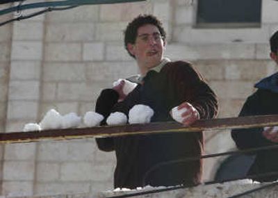 
A Jewish settler throws snowballs towards Palestinian youths in Hebron on Thursday. 
 (Associated Press / The Spokesman-Review)