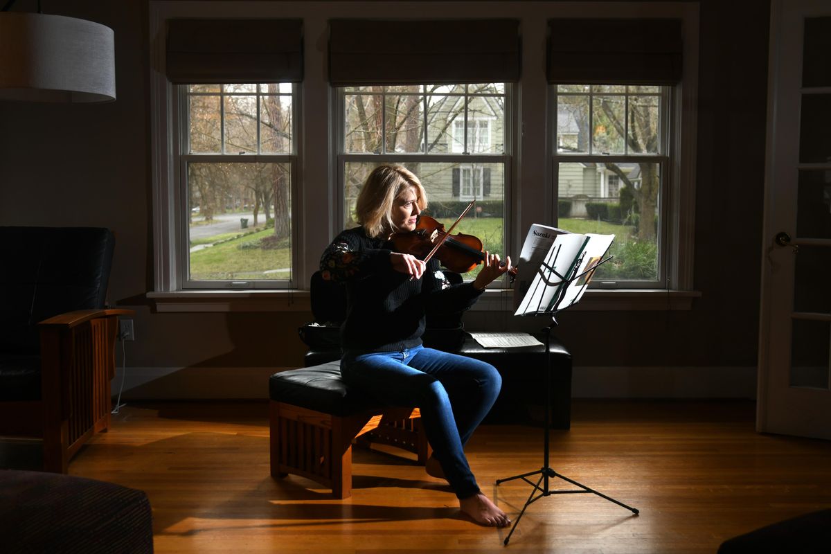 KXLY meteorologist Kris Crocker practices her other talent, playing violin, in her living room in Spokane. (Dan Pelle / The Spokesman-Review)