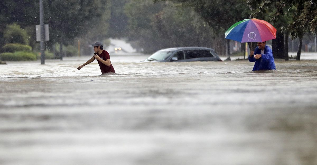 Moses Juarez, left, and Anselmo Padilla wade through floodwaters from Tropical Storm Harvey on Sunday, Aug. 27, 2017, in Houston, Texas. (David J. Phillip / Associated Press)