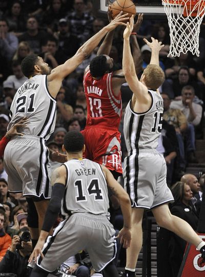 San Antonio’s Tim Duncan, left, reaches for one of his two blocks Sunday against Rockets guard James Harden in the second half. (Associated Press)