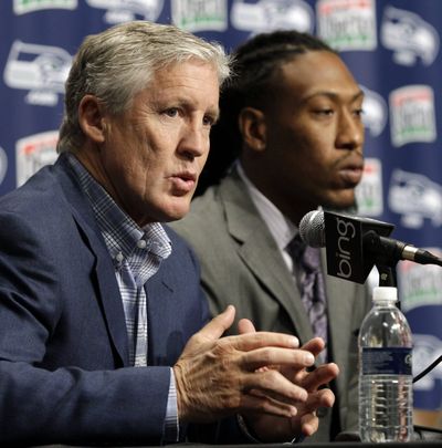 Seattle Seahawks head football coach Pete Carroll, left, talks about the team's top NFL football draft pick, Bruce Irvin, right, Saturday, April 28, 2012, in Renton, Wash. Irvin is a pass rush specialist who attended West Virginia. (Ted Warren / Associated Press)