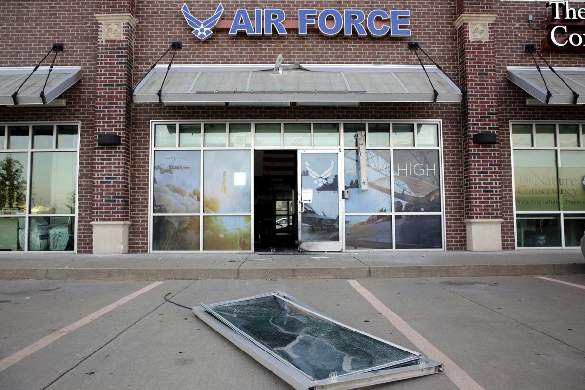 Glass and a door lie on the ground at the scene of an explosion at an Air Force recruiting office in Bixby, Okla.,  July 11, 2017, after an explosion Monday night outside an Air Force recruitment office. . (Mike Simons / AP)