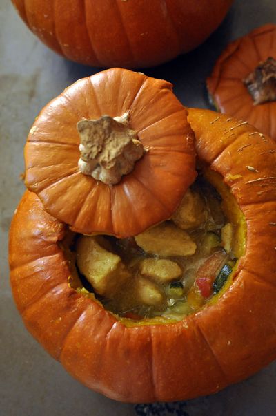 Stuffed with sweet or savory filling, like this coconut milk-based chicken dish, baked whole pumpkins make for simple yet stunning edible centerpieces. (Adriana Janovich / The Spokesman-Review)