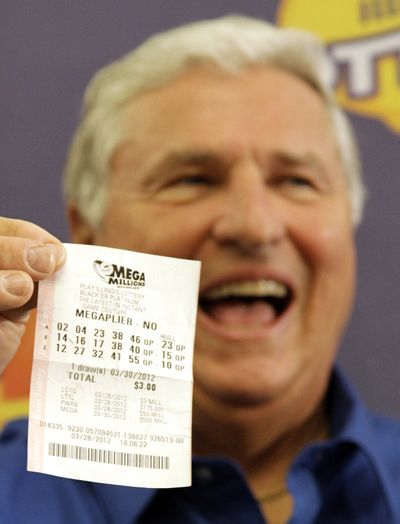 Merle Butler, of Red Bud, Ill., holds up his winning lottery ticket during a news conference at the Red Bud Village Hall on Wednesday, April 18, 2012, in Red Bud, Ill. The retired southern Illinois man and his wife have claimed the third and final share of last month's record $656 million Mega Millions jackpot. (Seth Perlman / Associated Press)
