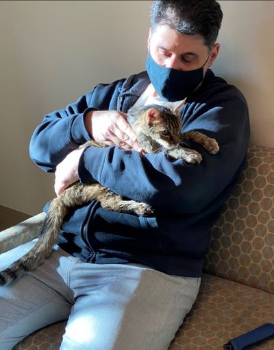 This photo provided by the Los Angeles County Department of Animal Care and Control shows Brandy, a brown tabby cat, that was reunited on Monday, Feb. 22, 2021, with her owner, Charles, (he would only give his first name) after she went astray for 15 years, are seen together at the Palmdale, Calif., animal care center. The Los Angeles man adopted her as a 2-month-old kitten in 2005. Charles says he cried and Brandy purred in his arms. The brown tabby was found Sunday in Palmdale, about a half-hour's drive from where he lives.  (HOGP)