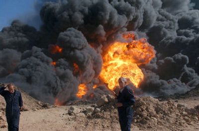 
An Iraqi oil worker stands near a burning oil pipeline near Kirkuk on Oct. 20. Insurgents using explosives set fire to the pipeline. 
 (File/Associated Press / The Spokesman-Review)