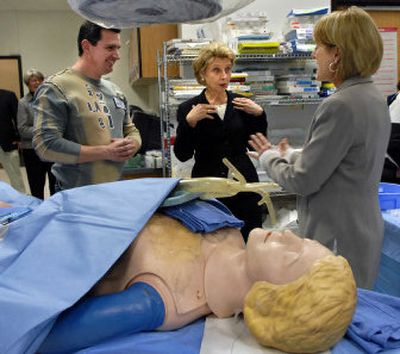 
Spokane Community College students Kris Brown, right, and Alexander Kapustin, left,  offer to let Gov. Chris Gregoire to try a procedure on a mannequin during a campus tour Friday.
 (Dan Pelle / The Spokesman-Review)