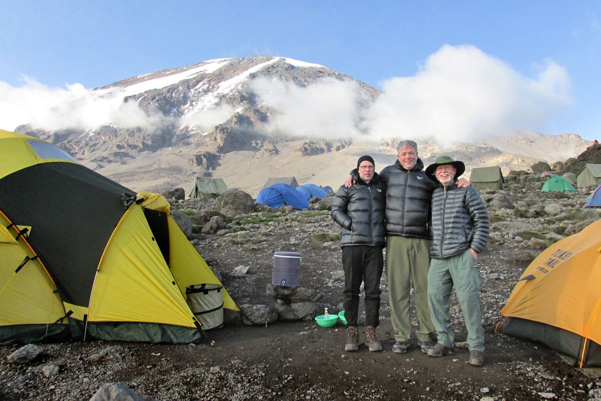 With Kilimanjaro in the background, friends Mark Iverson, Kim Erickson and Nick Follger share a moment on their way to the summit. (Nick Follger)
