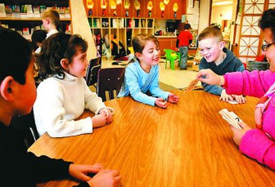 
Kindergarteners Ava McClintock, center, Mykael Maddox, center right, try to name letters and sounds on cards held by teacher Jacque Dean, right, in the all-day kindergarten class at Atlas Elementary in Hayden. At left are Emigdio Guzman-Contreras and Tayler Holbert, second from left. For kids who need reading and language help, the all-day kindergarten reinforces what half-day kindergarteners are learning. 
 (Jesse Tinsley / The Spokesman-Review)