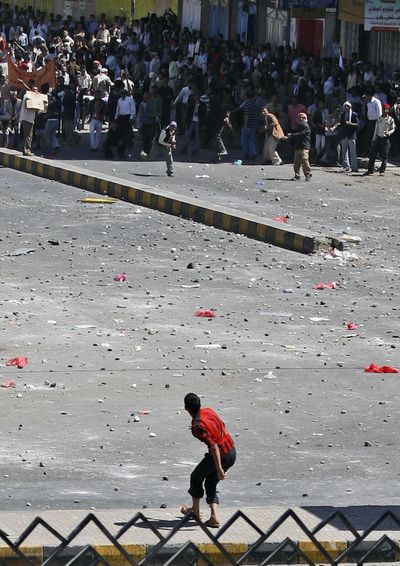A supporter of the Yemeni government prepares to hurl a stone at anti-government demonstrators, during clashes in Sanaa, Yemen. (Associated Press)