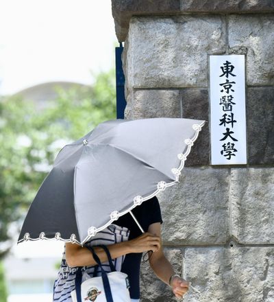 A woman walks past the gate of Tokyo Medical University on Aug. 2, 2018. The Japanese medical university’s alleged systematic deduction of entrance exam scores only from female applicants has sparked outrage across Japan and invited criticisms from Cabinet officials. The scandal surfaced after the Yomiuri newspaper reported Thursday that Tokyo Medical University has been slashing female applicants entrance exam scores for years to keep female student population low, on grounds they tend to quit as doctors after starting families, causing staffing shortages. (Ayaka Aizawa / Kyodo News)