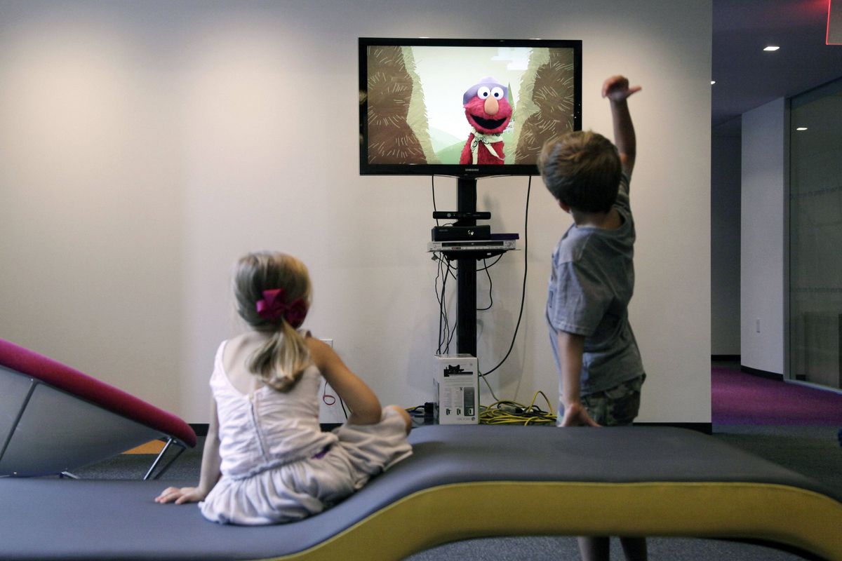 Zoe Shyba, left, and Aidan Lain play “Kinect Sesame Street TV” at the Sesame Workshop in New York on Sept. 5. The interactive program uses Kinect, a motion and voice-sensing controller created by Microsoft. (Associated Press)