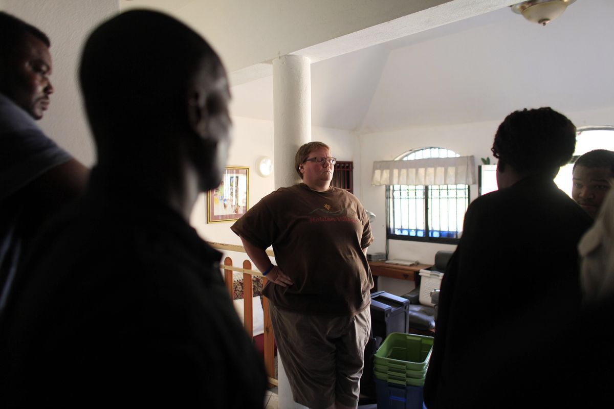 Haitian authorities questions Renee Dietrich, communications director of Wings of Hope, about Michael Geilenfeld’s whereabouts Friday during an arrest warrant search at the home in the mountainside town of Kenscoff, on the outskirts of Port-au-Prince, Haiti. (Ricardo Arduengo / Associated Press)
