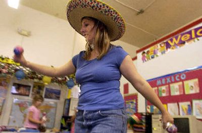 
Preschool teacher Jamie McGinnis leads her pupils through a dance using their homemade maracas during a fiesta in their classroom at Kindergarten Con Carina. 
 (Jesse Tinsley / The Spokesman-Review)