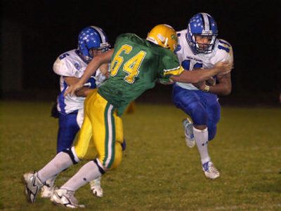 
Coeur d'Alene's Jerrett Moss (5) gets enough of a block on Lakeland's Lynn Mallory (64) to spring Kevin Ah-Hi (11) for a first down Friday night.
 (Tom Davenport/ / The Spokesman-Review)