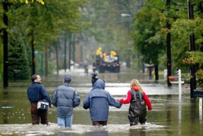
Residents wade through a flooded street to check on their homes Thursday in the Hoffman Grove section of Wayne, N.J. 
 (Associated Press / The Spokesman-Review)