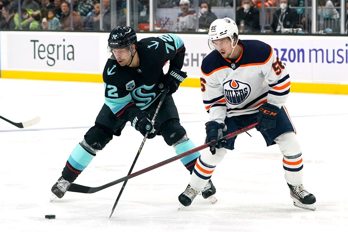 Seattle Kraken’s Joonas Donskoi 72) and Edmonton Oilers’ Kailer Yamamoto (56) eye the puck in the first period of an NHL hockey game Saturday, Dec. 18, 2021, in Seattle.  (Elaine Thompson)
