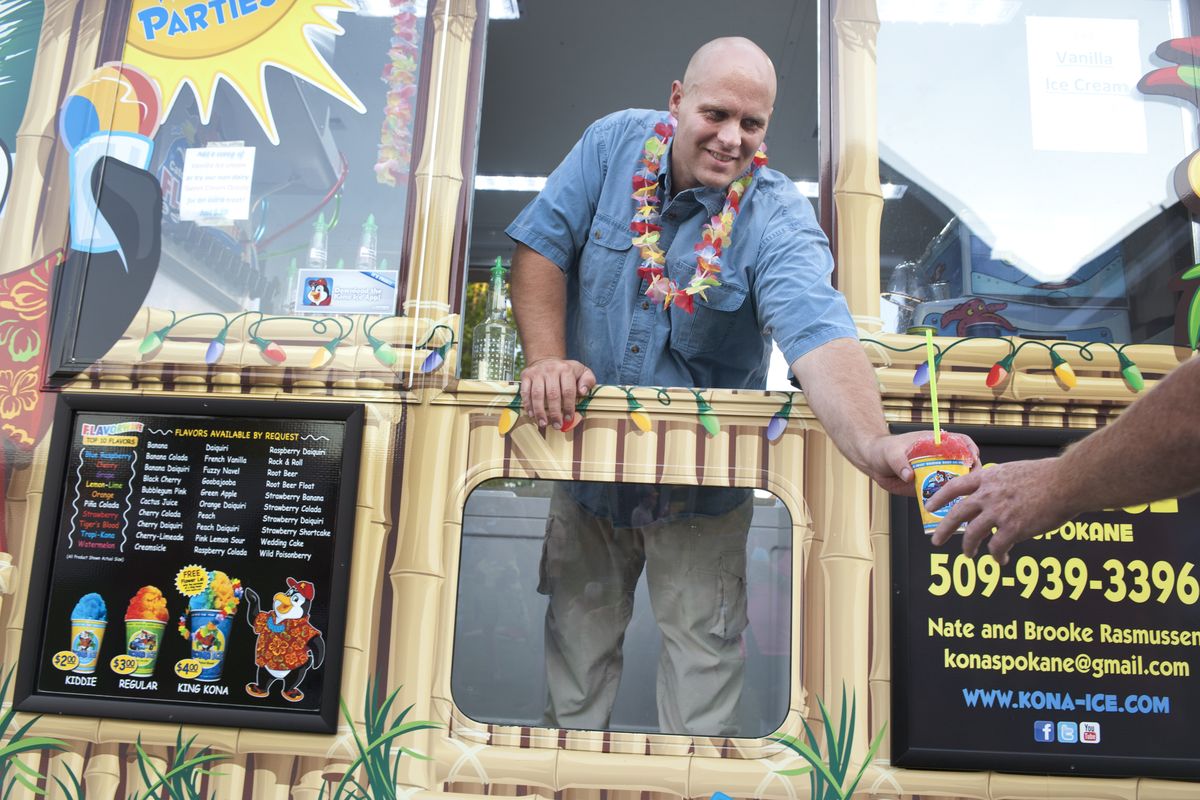 Nate Rasmussen, co-owner of Kona Ice, serves shave ice to a birthday party last week in Greenacres. The truck can be found at fairs, festivals, schools, sporting events and, in the evenings, often in Spokane Valley. (Tyler Tjomsland)