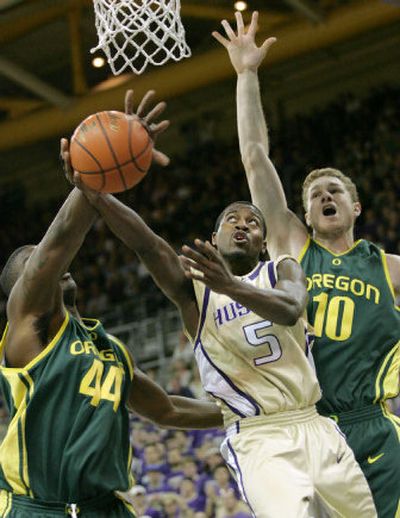 
Washington's Justin Dentmon has his shot blocked by Oregon's Ivan Johnson (44) with Maarty Leunen also defending.
 (Associated Press / The Spokesman-Review)