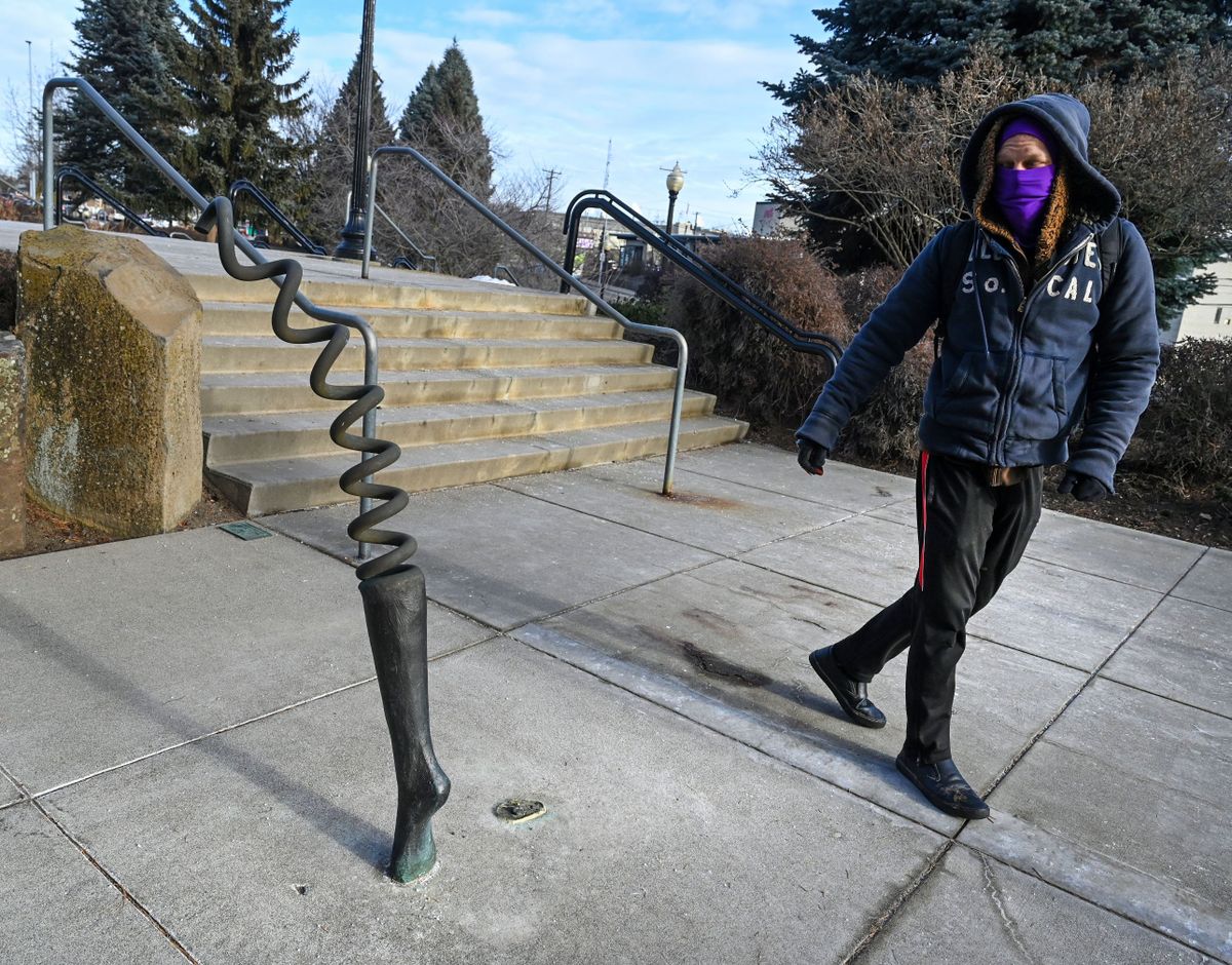 While on his daily route to work at Clinkerdagger in the Flour Mill, Caleb Preiss passes the "Leap" sculpture outside the Spokane Veterans Memorial Arena Tuesday, Jan. 16, 2024. The leg has gone missing from the Phillip Levine art piece.  (DAN PELLE/THE SPOKESMAN-REVIEW)