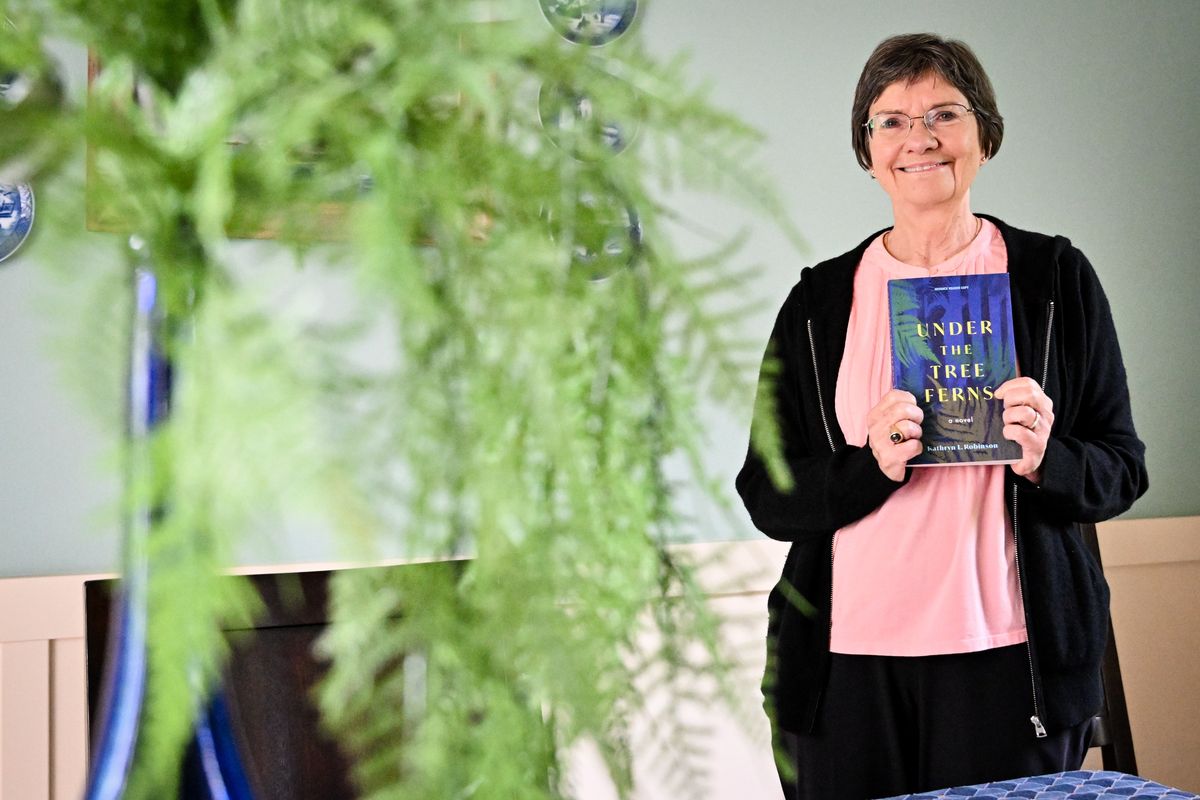 Author Kathryn Robinson shows off her new book “Under The Tree Ferns” on June 9 in Spokane.  (Tyler Tjomsland/The Spokesman-Review)