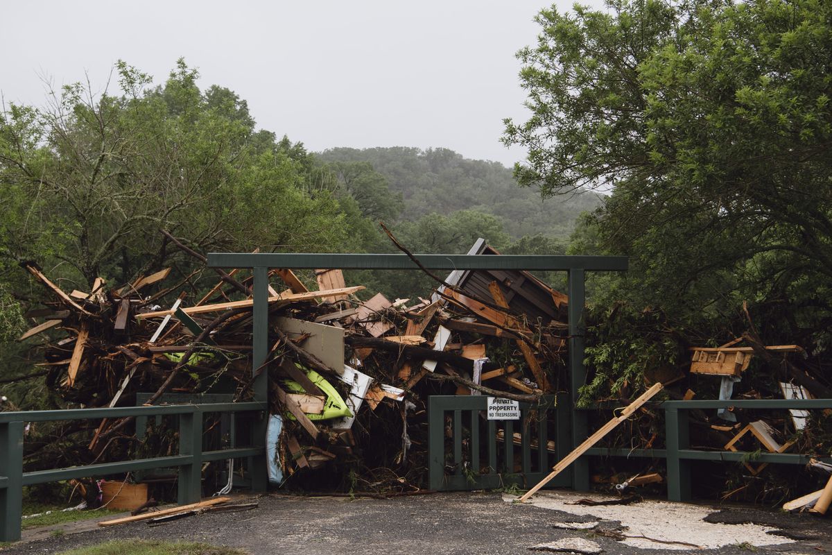Debris left by the flooded Guadalupe River is piled against a gate in Hunt, Texas, on Saturday. (CARTER JOHNSTON/New York Times)