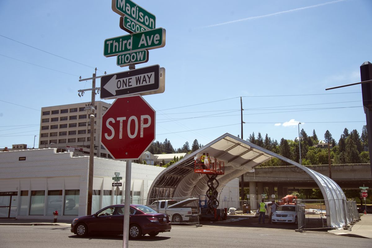 Workmen assemble an arched storage building on Madison St. betweeen Third Ave. and Fourth Ave. on the Larry H. Miller car dealership campus Friday, May 22, 2015.  Miller is asking the city to vacate Madison from Second Ave. to Fourth Ave. so the expanding dealership can connect several blocks of car lots, showrooms and service buildings. (Jesse Tinsley / The Spokesman-Review)