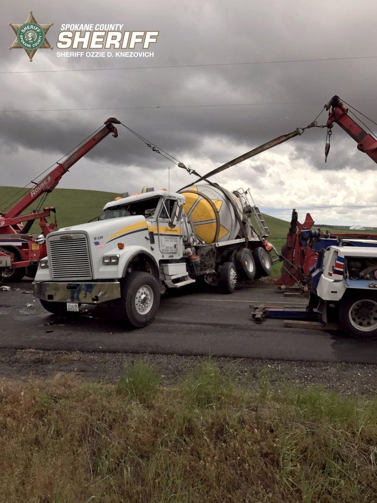 Several tow trucks lifted a cement truck back up on its wheels after it flipped on Wells Road on Friday, June 16, 2017. (Spokane County Sheriff’s Office)