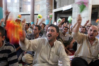 
Iraqis wave flowers during prayers at the Al-Rahman Shiite mosque in Baghdad Friday in memory of those killed in the bombings on Sept. 14 in the northern Kazimiyah suburb of the Iraqi capital. 
 (Associated Press / The Spokesman-Review)