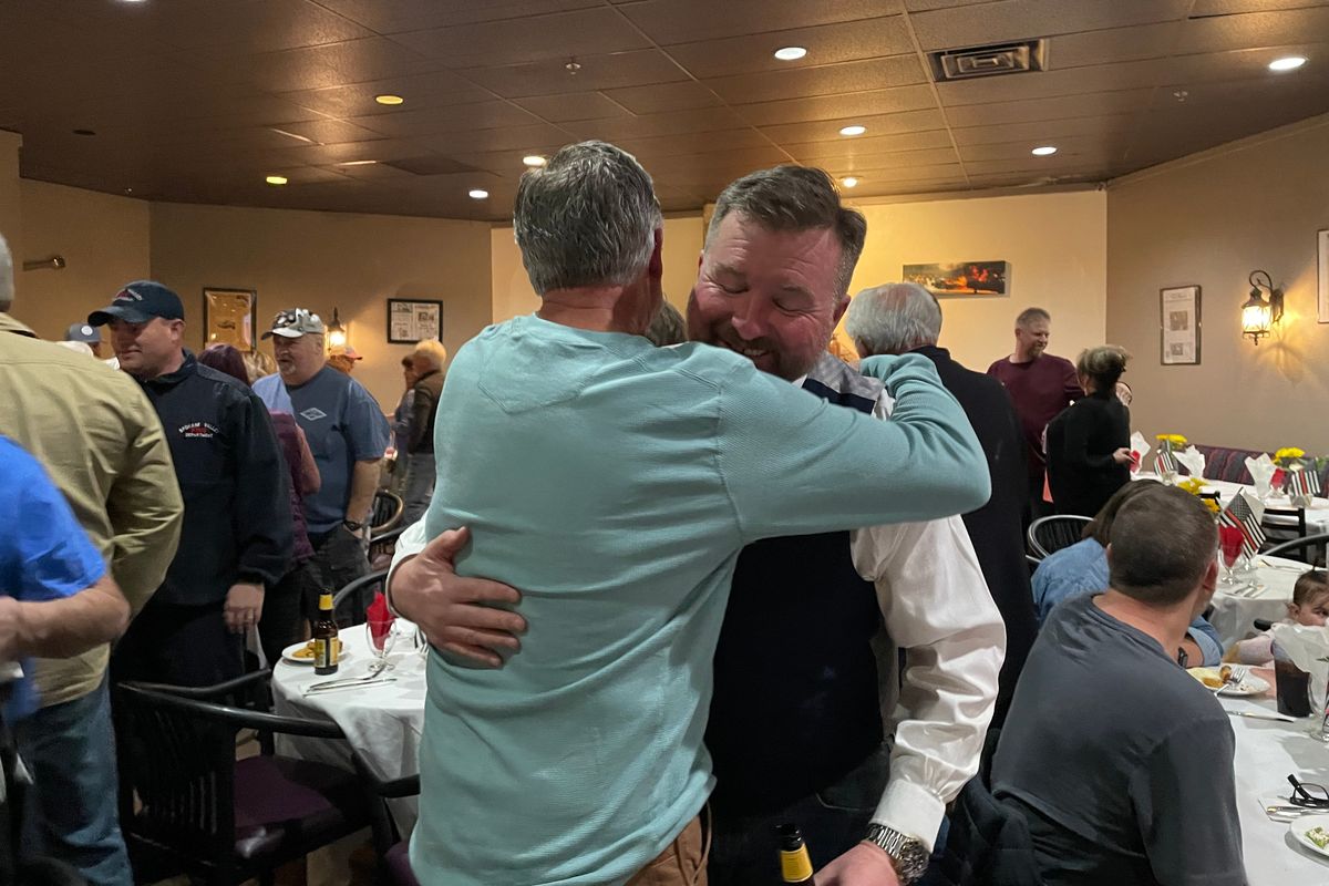 Rick Freier, right, exchanges a hug with Captain Duane Hughe during a retirement party on Friday, March 31, 2023, in Spokane Valley.  (Nina Culver/For The Spokesman-Review)
