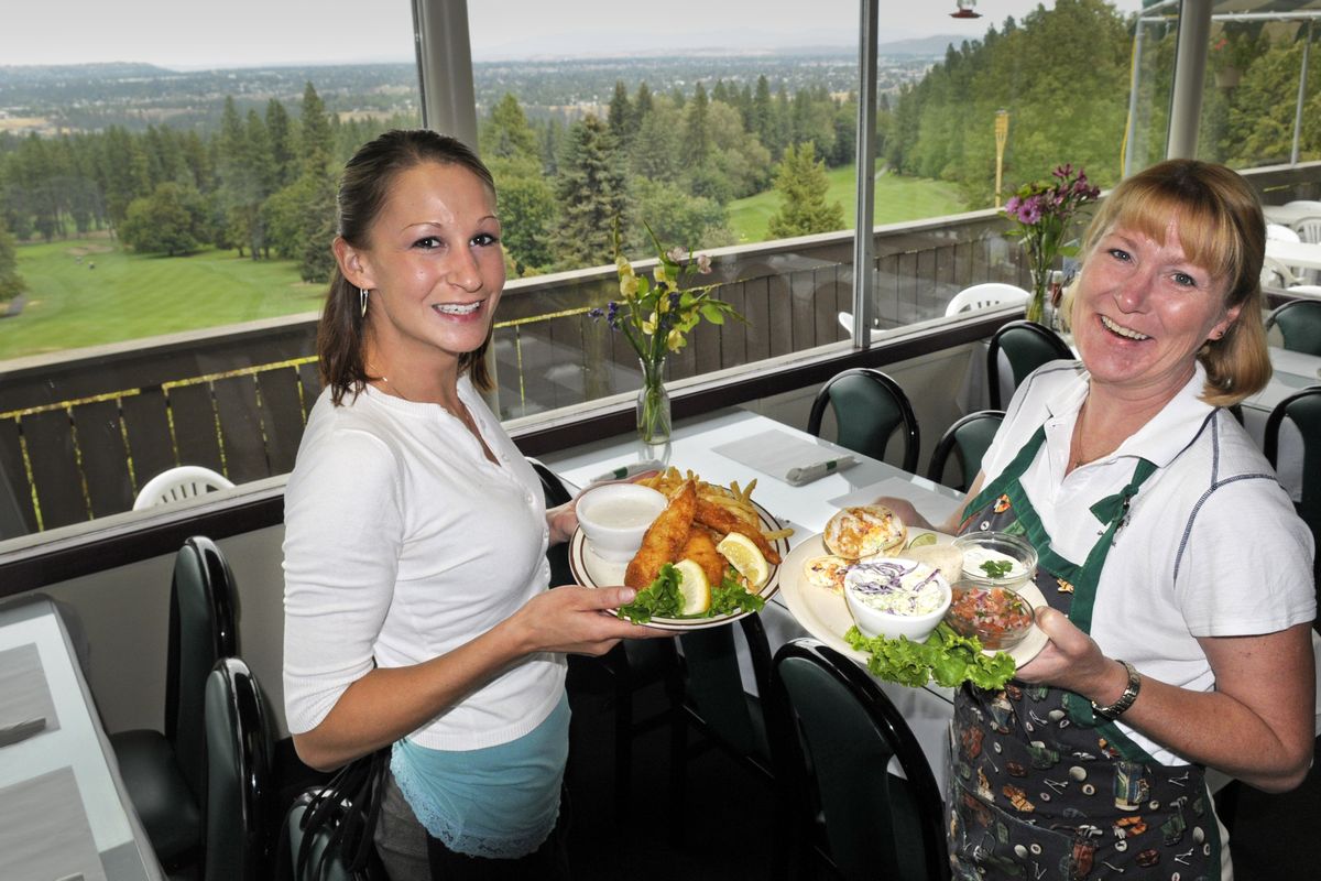Megan Gale, left, holds a serving of fish and chips while Alisa Hagens prepares to serve fish tacos at the Indian Canyon Restaurant. The renovated eatery features fresh, handmade entrees, soups and side dishes, Wi-Fi and an extensive wine list to go with panoramic views of the city from the top of Sunset Hill overlooking Spokane’s most famous golf course.  (Christopher Anderson)