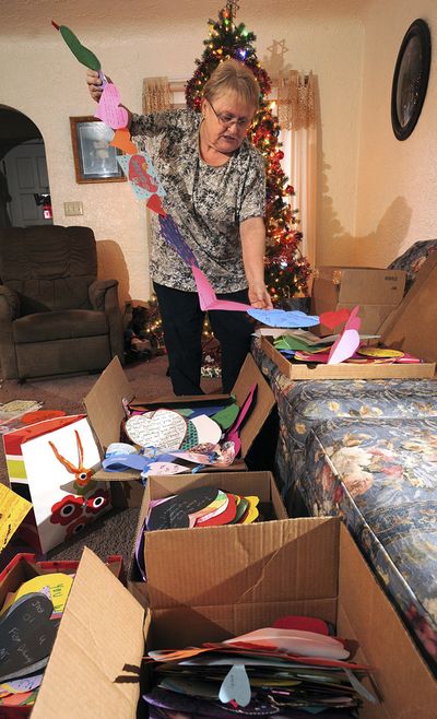 Joy Manning, neighbor of program coordinator Gala Thompson, sorts some of the hundreds of paper hearts received as part of the Paper Hearts Across America program, in Billings on Monday. (Associated Press)