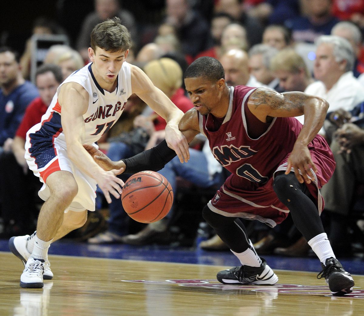Gonzaga’s David Stockton, left, and Loyola Marymount’s Taylor Walker close in on basketball in first half of Saturday’s game. (Colin Mulvany)