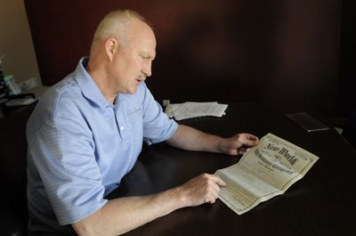 Farmers Insurance agent David Boley looks at a 1940 insurance policy written on a man who recently died. It was a whole life policy that matured in the 1970s and had a face value of $1,000. Because of interest, it will pay around $2,800.  (Jesse Tinsley / The Spokesman-Review)