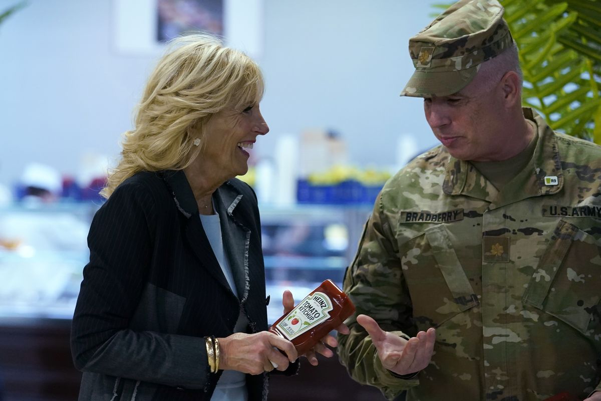 First lady Jill Biden, left, gives bottles of ketchup to Major Shawn Bradberry, U.S. Army Deputy Host Nation Advisor for Romania, right, during her visit to the Mihail Kogalniceanu Air Base in Romania, Friday, May 6, 2022. The base was out of ketchup. Biden also served meals to and visit with some of the U.S. troops assigned to the base during her visit. (Susan Walsh)