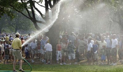 
A course worker sprays water on fans to help cool them down during the third round of the PGA Championship at Baltusrol Golf Club, where temperatures reached triple-digits. 
 (Associated Press / The Spokesman-Review)