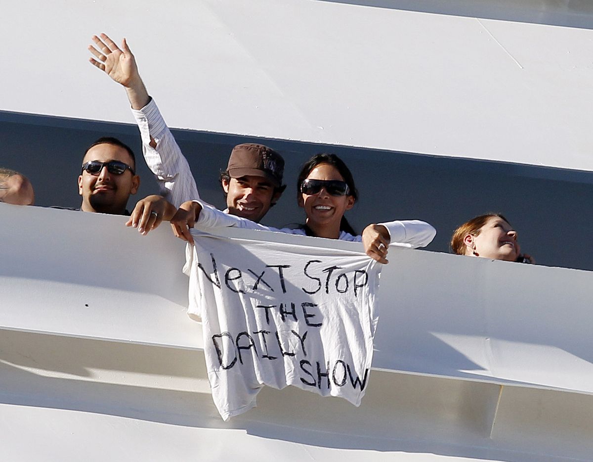 A couple on board the Carnival Splendor cruise ship hold a T-shirt with the message "Next Stop The Daily Show" written on it as the ship approaches the dock in San Diego, Calif., Thursday, Nov. 11, 2010. (Jae Hong / Associated Press)